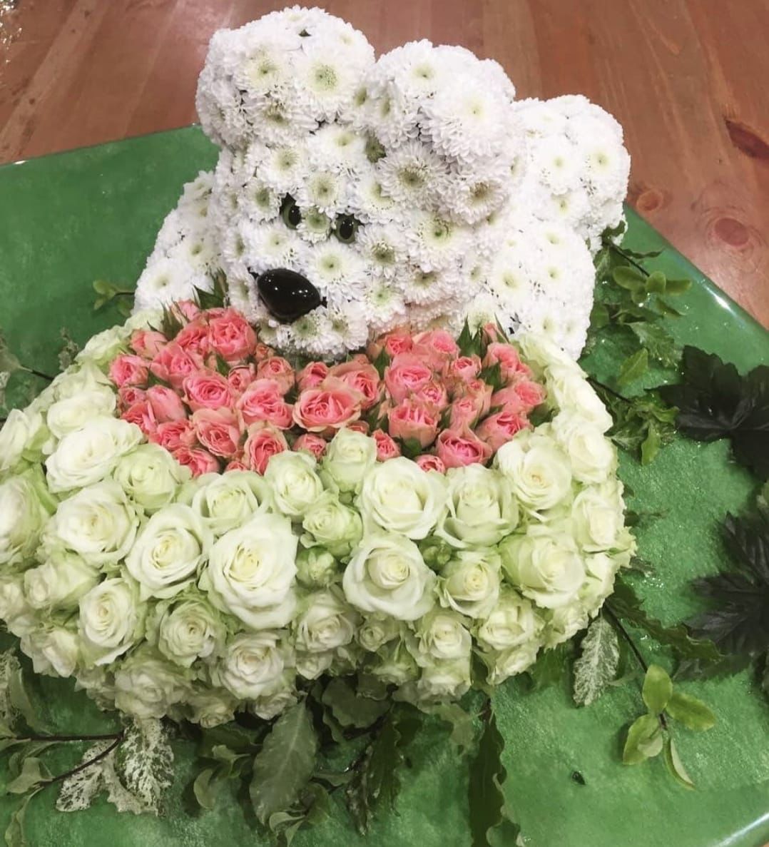 Букет №18 «Мишка из роз на зелёной лужайке»: композиция из белых хризантем (Santini),
                 розовых кустовых роз, белых и светло-зелёных роз, с декоративной зеленью и элементами
                 для глаз и носа, на зелёной подложке, размер мишки — 50 см. Доставка цветов в Домодедово.