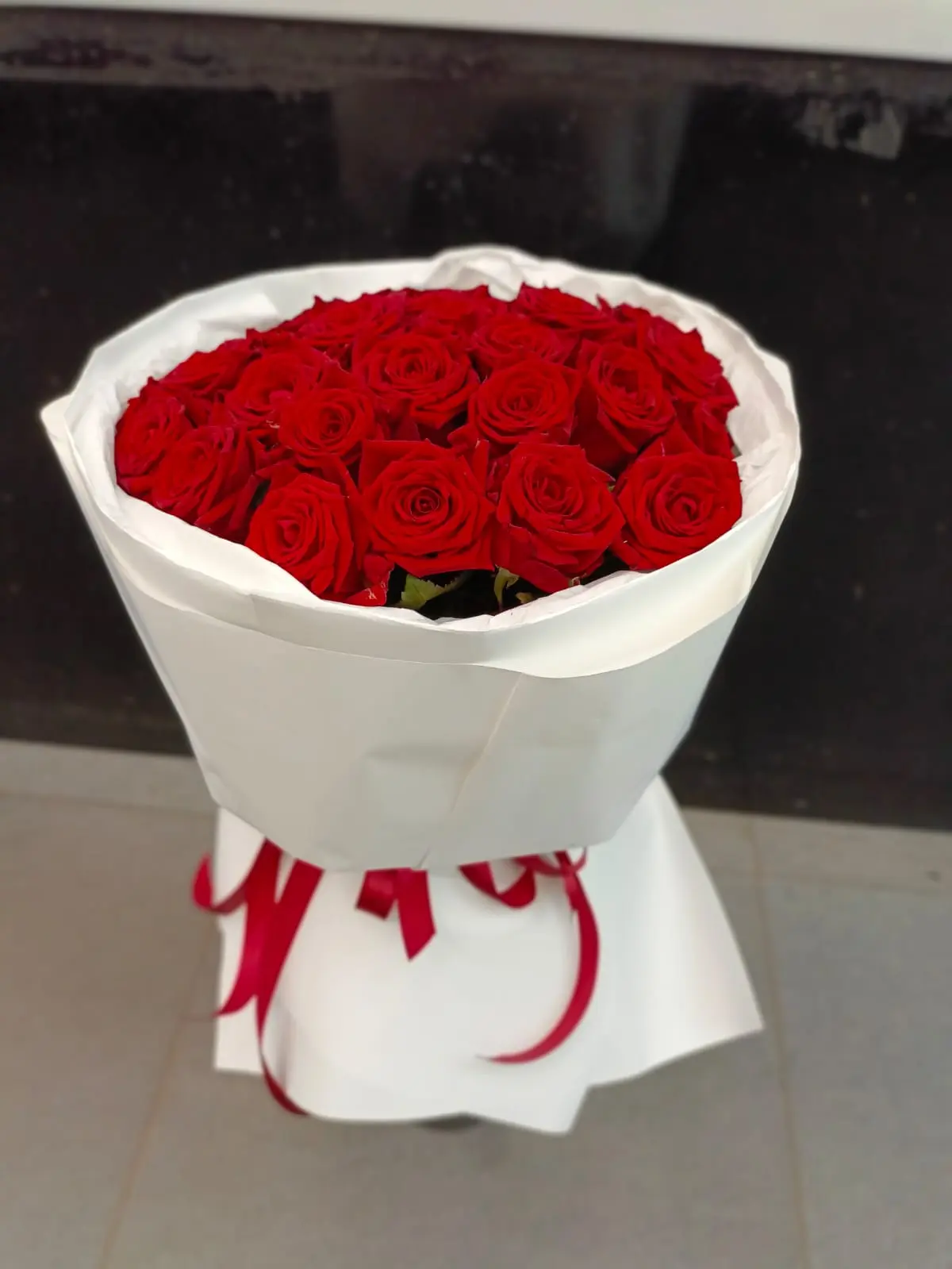 Букет № 68: 31 красная роза высотой 60 см
                 в белой крафтовой упаковке с бумагой тишью и атласной красной лентой. Доставка цветов в Коломне