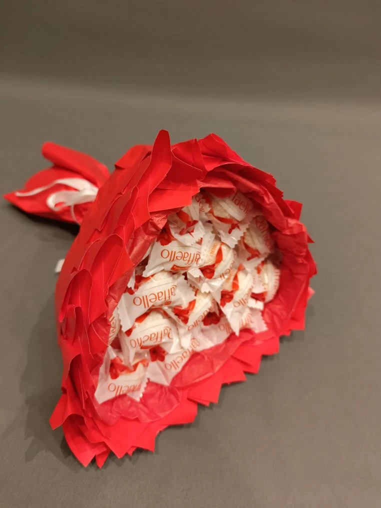 Сладкий букет № 10 в форме сердца: 15 конфет Raffaello, украшенные ярко-красной упаковкой и бумагой тишью. Дополнен белой атласной лентой.
                 Основа — пенопласт в форме сердца, ручка из бамбуковых шпажек. Трогательный сладкий подарок в Коломне