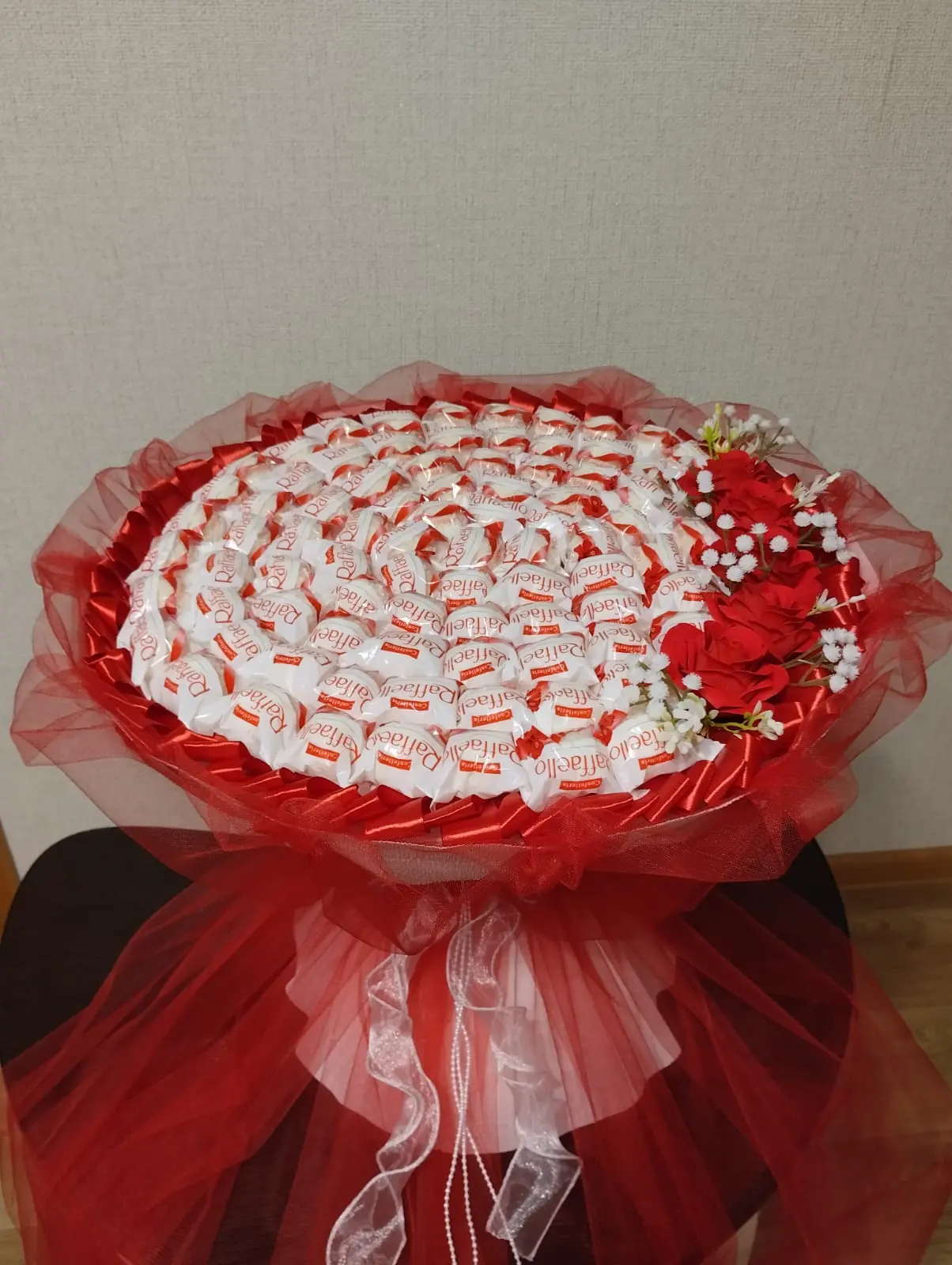 Сладкий букет № 2 из 72 конфет „Raffaello“, украшенный атласной и капроновой лентами, декоративной бабочкой, стразами и искусственными цветами. Композиция оформлена в гофрированной бумаге,
                     с ручкой из бамбуковых шпажек. Элегантный подарок в Коломне, доставка в Коломне