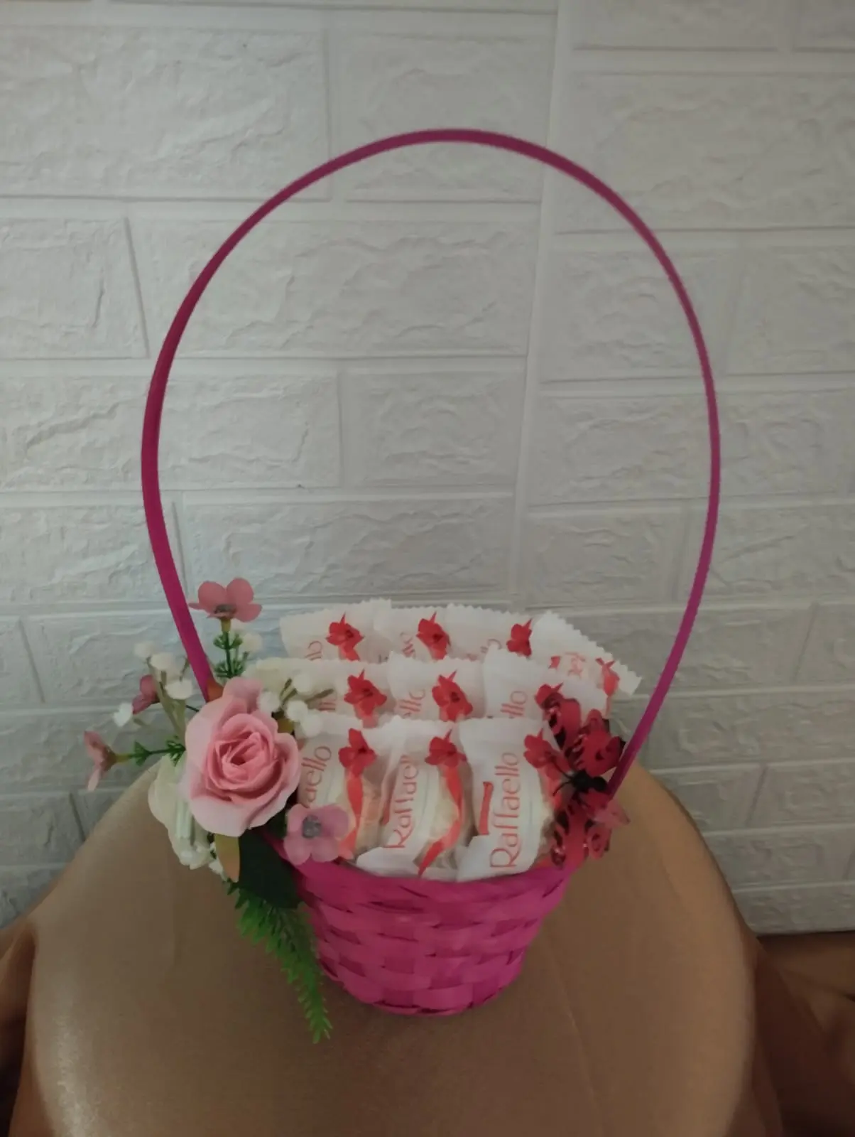 Сладкий букет № 13: 10 конфет „Raffaello“ в плетёной розовой корзине,
                 украшенной декоративной бабочкой и искусственными цветами. Цена: 2 000 ₽